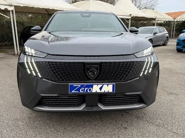 Vue frontale du Peugeot 3008 Hybrid gris titane avec calandre noire et feux LED à triple griffes distinctifs.