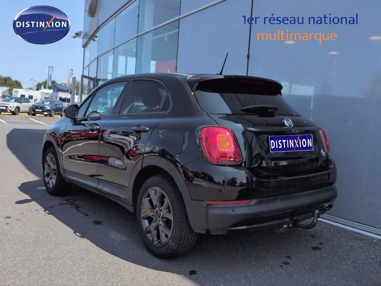 Vue 3/4 arrière droite d'une FIAT 500X noire Cinéma pastel avec jantes alu et becquet arrière.