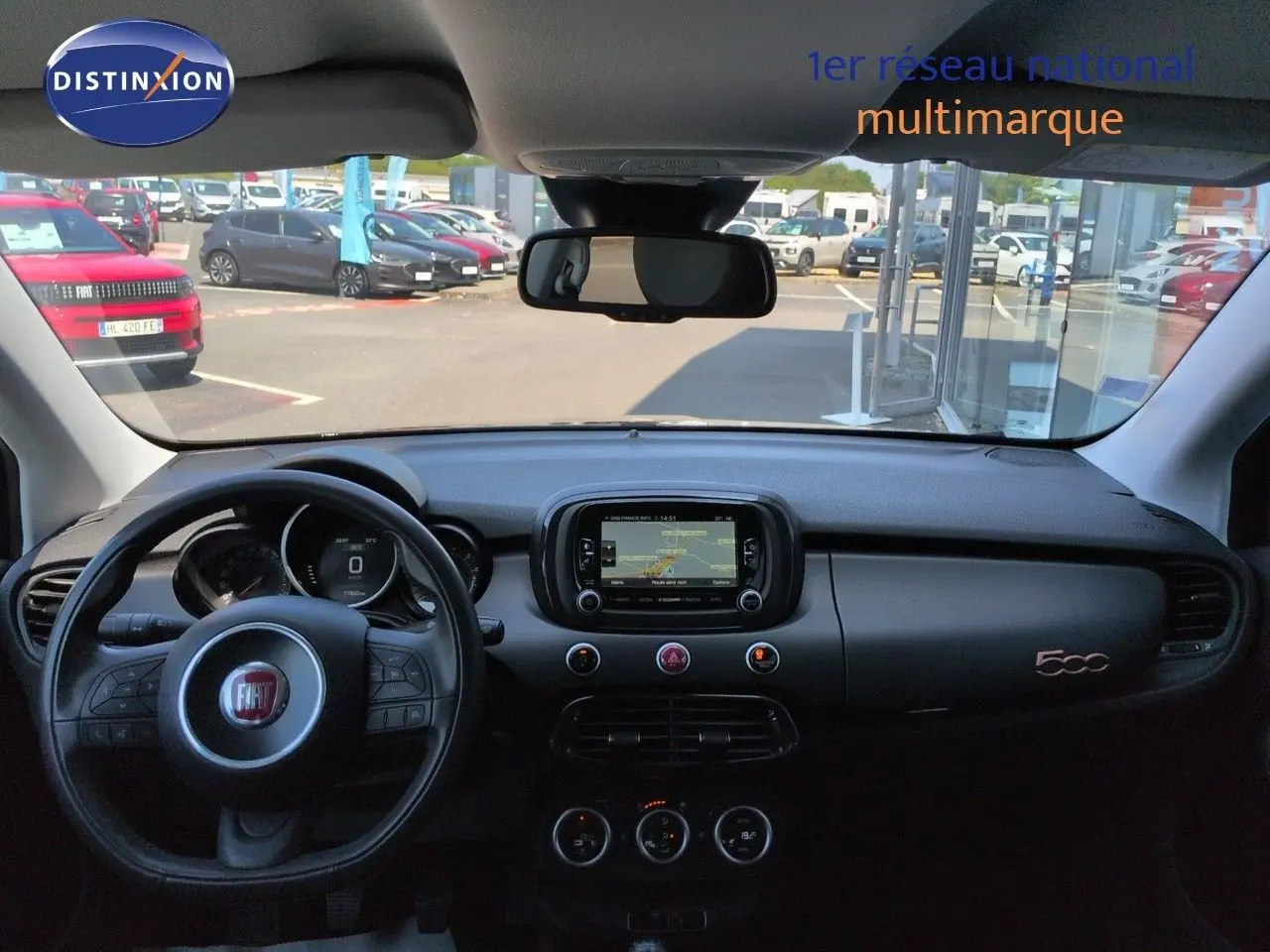 Vue intérieure du tableau de bord noir d'une Fiat 500X 2018 avec écran tactile et volant multifonction.