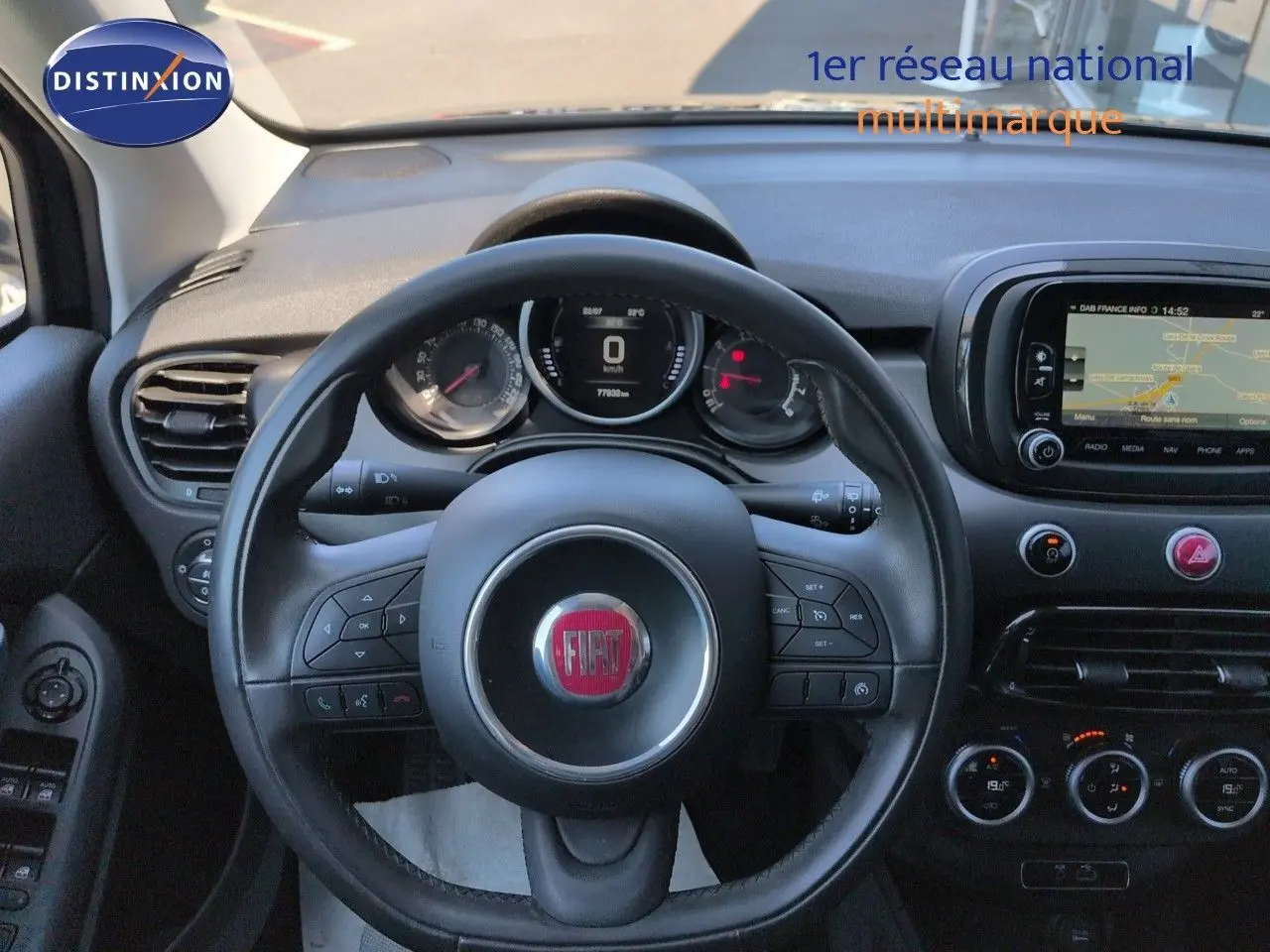 Vue intérieure centrée sur le volant cuir multifonction et le tableau de bord avec écran tactile du Fiat 500X noir.