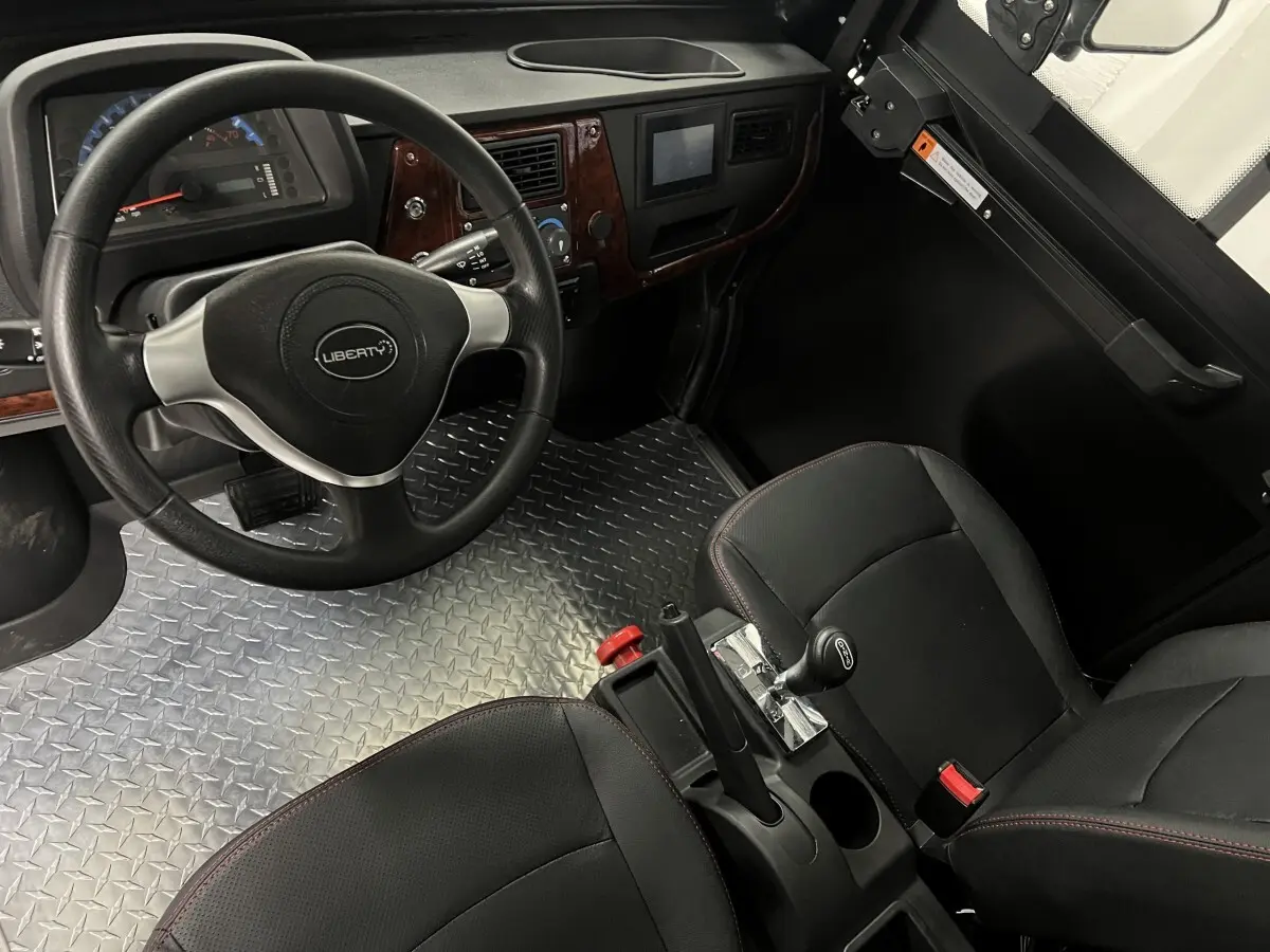 Intérieur vu côté conducteur du Liberty L7e H2 Cargo 2025, volant 3 branches, sol aluminium antidérapant et sièges noirs.