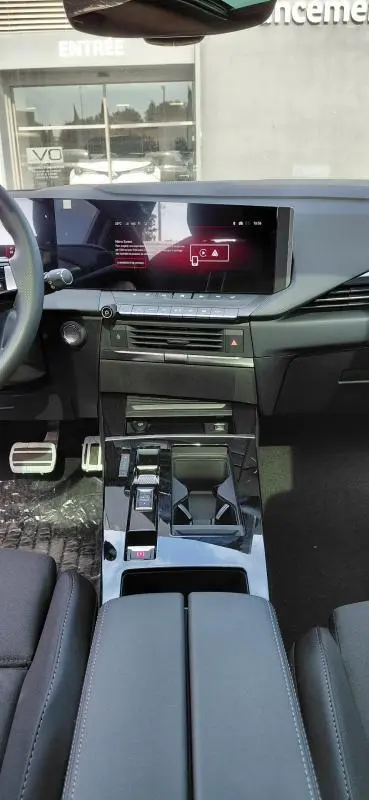Vue intérieure de l’Opel Astra 2025 diesel noire, montrant la console centrale moderne avec écran tactile et commandes automatiques.