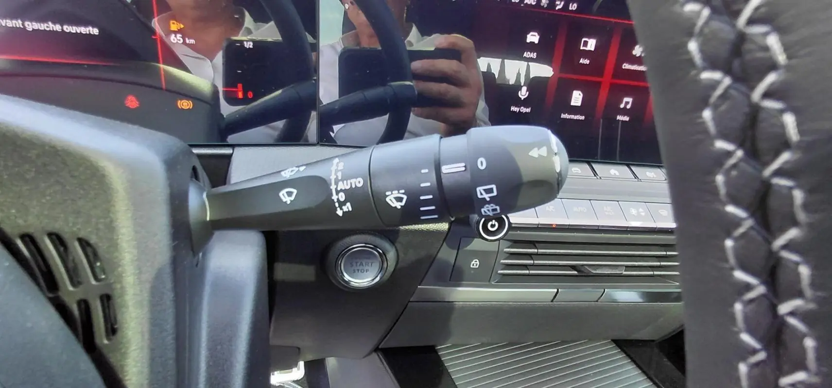 Gros plan sur la commande d’essuie-glace et le bouton start/stop de l’Opel Astra noire 2025, vue côté gauche du volant.