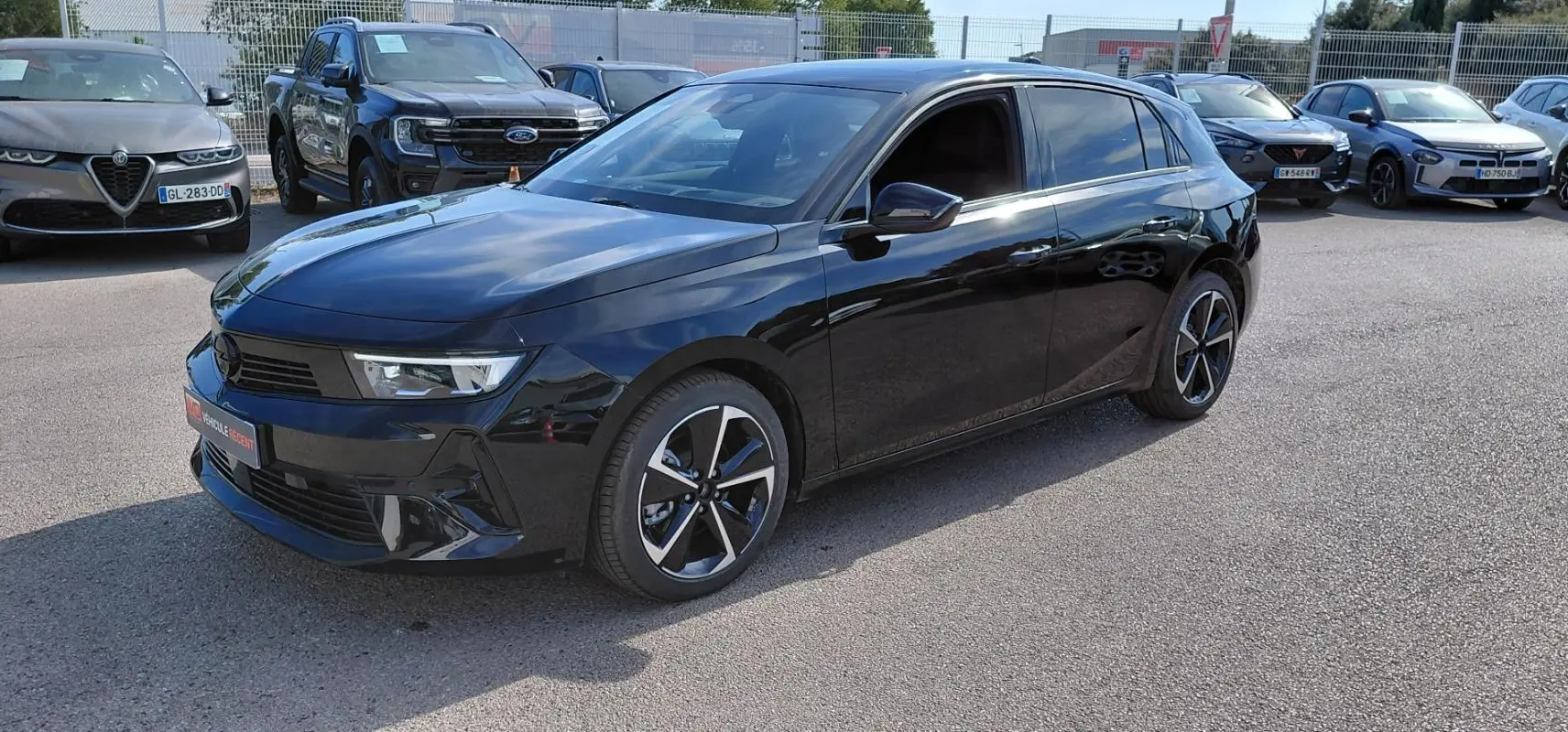 Opel Astra noire 2025 vue 3/4 avant droit, avec jantes alliage bicolores et vitres teintées.