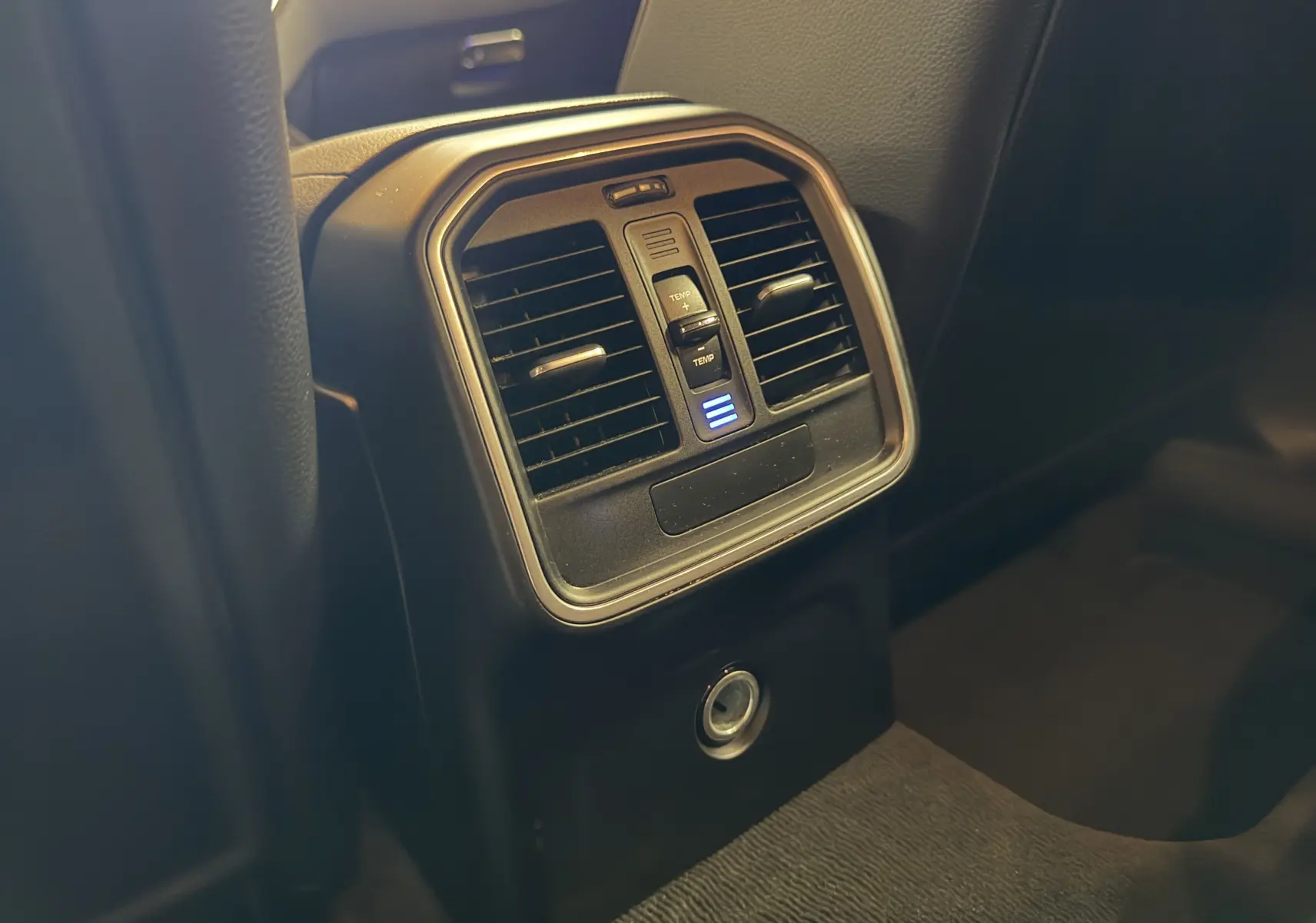 Détail de la console arrière noire du Porsche Macan S avec bouches d’aération et réglage de température éclairé.