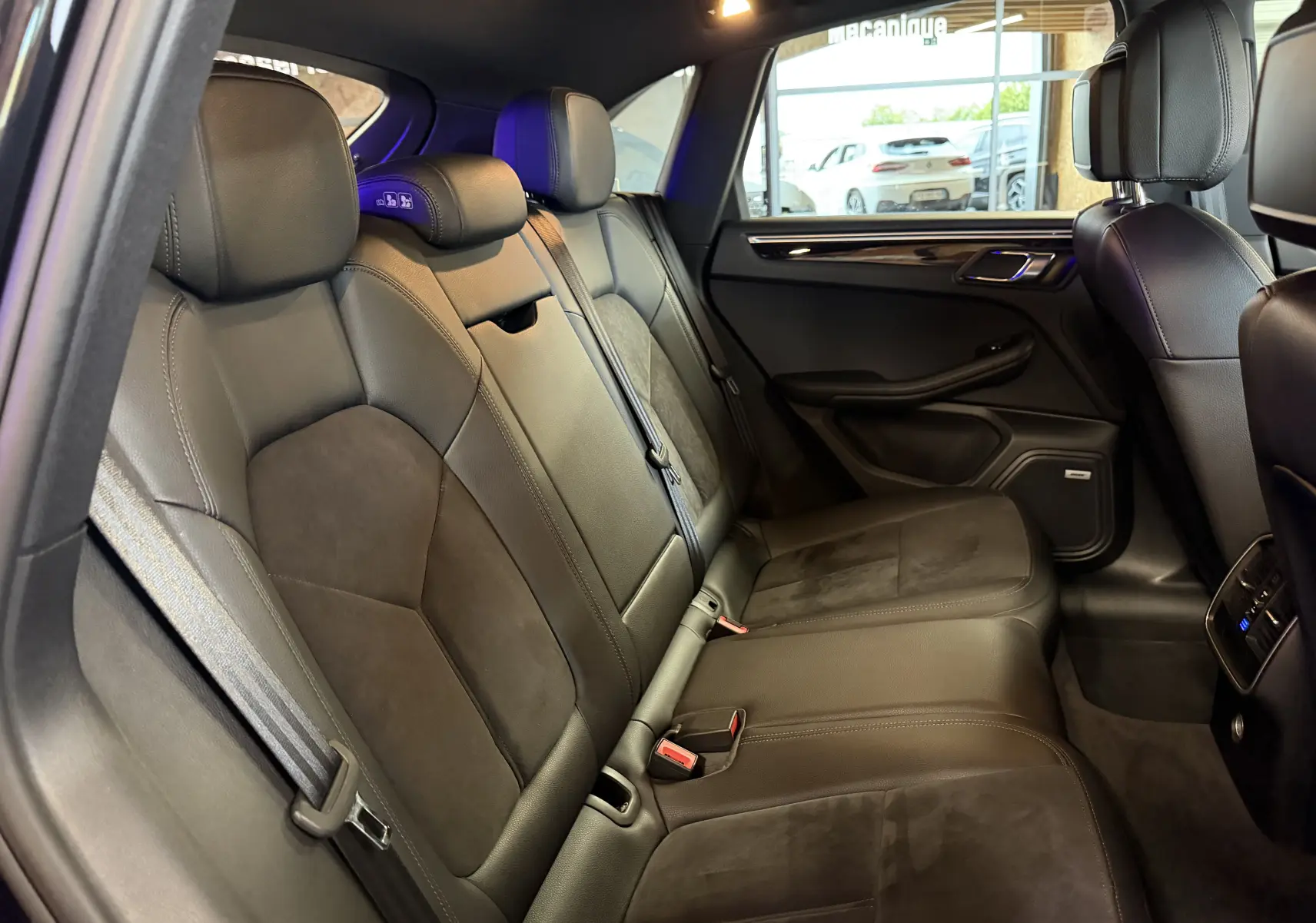 Vue intérieure côté droit des sièges arrière en cuir noir du Porsche Macan S 3.0i avec finitions élégantes et appuie-têtes réglables.