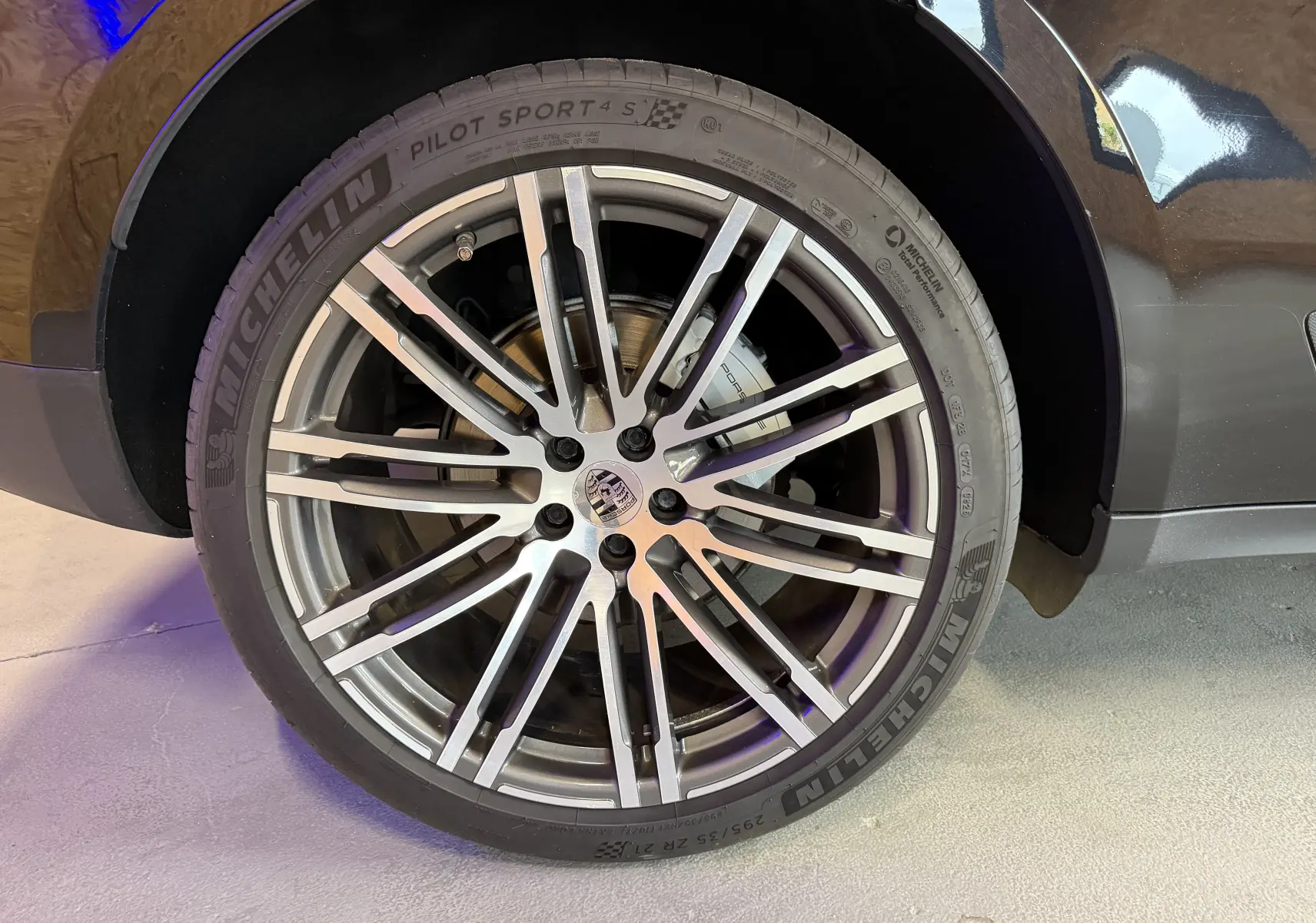 Gros plan sur la roue avant droite noire d'une Porsche Macan S avec jante alu 21 pouces et pneu Michelin Pilot Sport 4S.