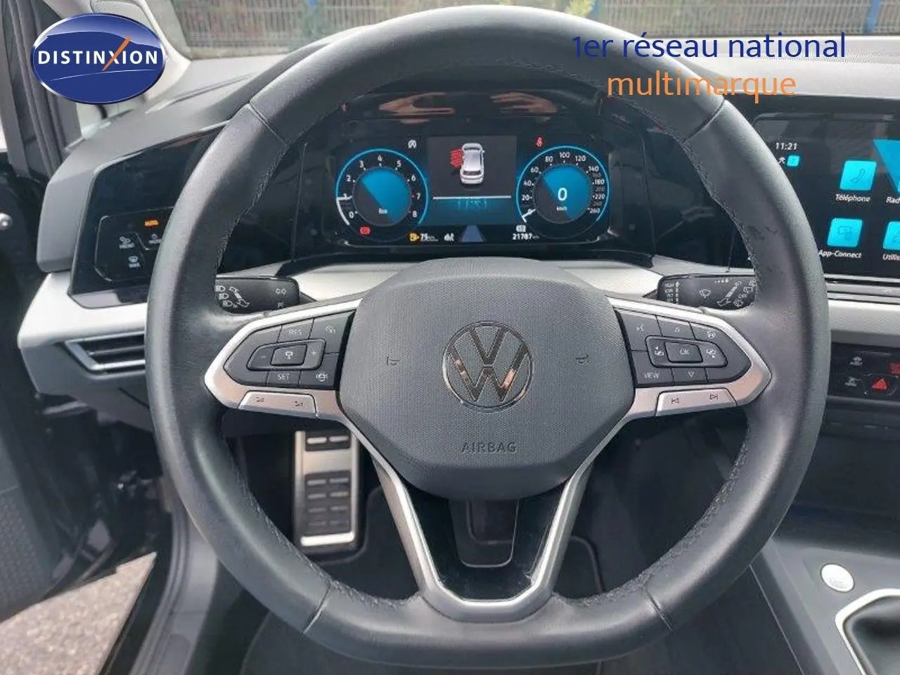 Vue rapprochée du volant noir de la Volkswagen Golf 1.5 TSI 150CH 2024 avec tableau de bord digital et commandes intégrées.