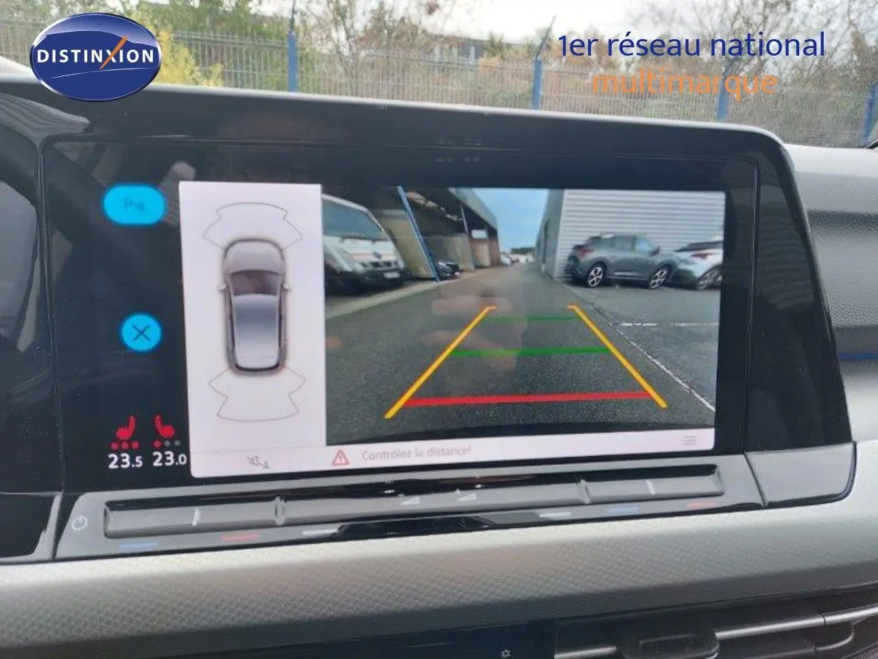 Vue intérieure du tableau de bord de la Volkswagen Golf 2024, écran affichant la caméra de recul avec repères colorés.