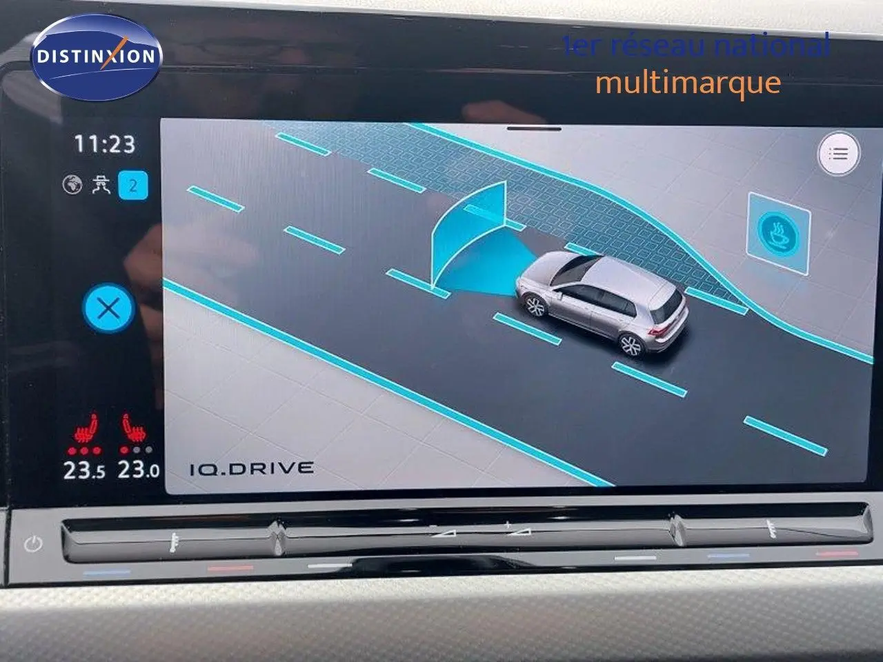 Écran intérieur montrant l'assistance à la conduite d'une Volkswagen Golf noire métal, vue de dessus en simulation.