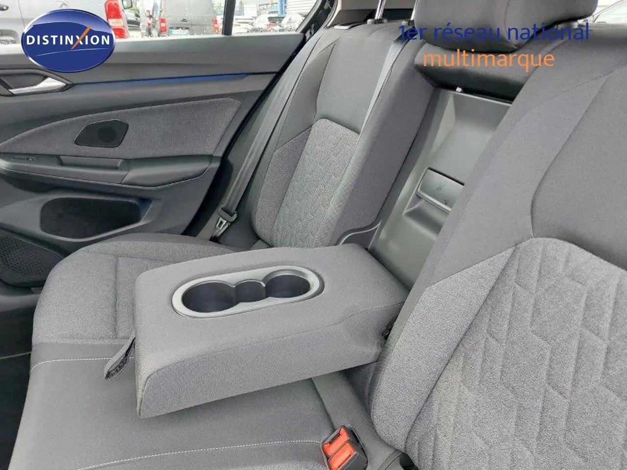 Vue intérieure côté droit des sièges arrière gris tissu avec accoudoir central rabattable et porte-gobelets de la Volkswagen Golf 1.5 TSI 2024.