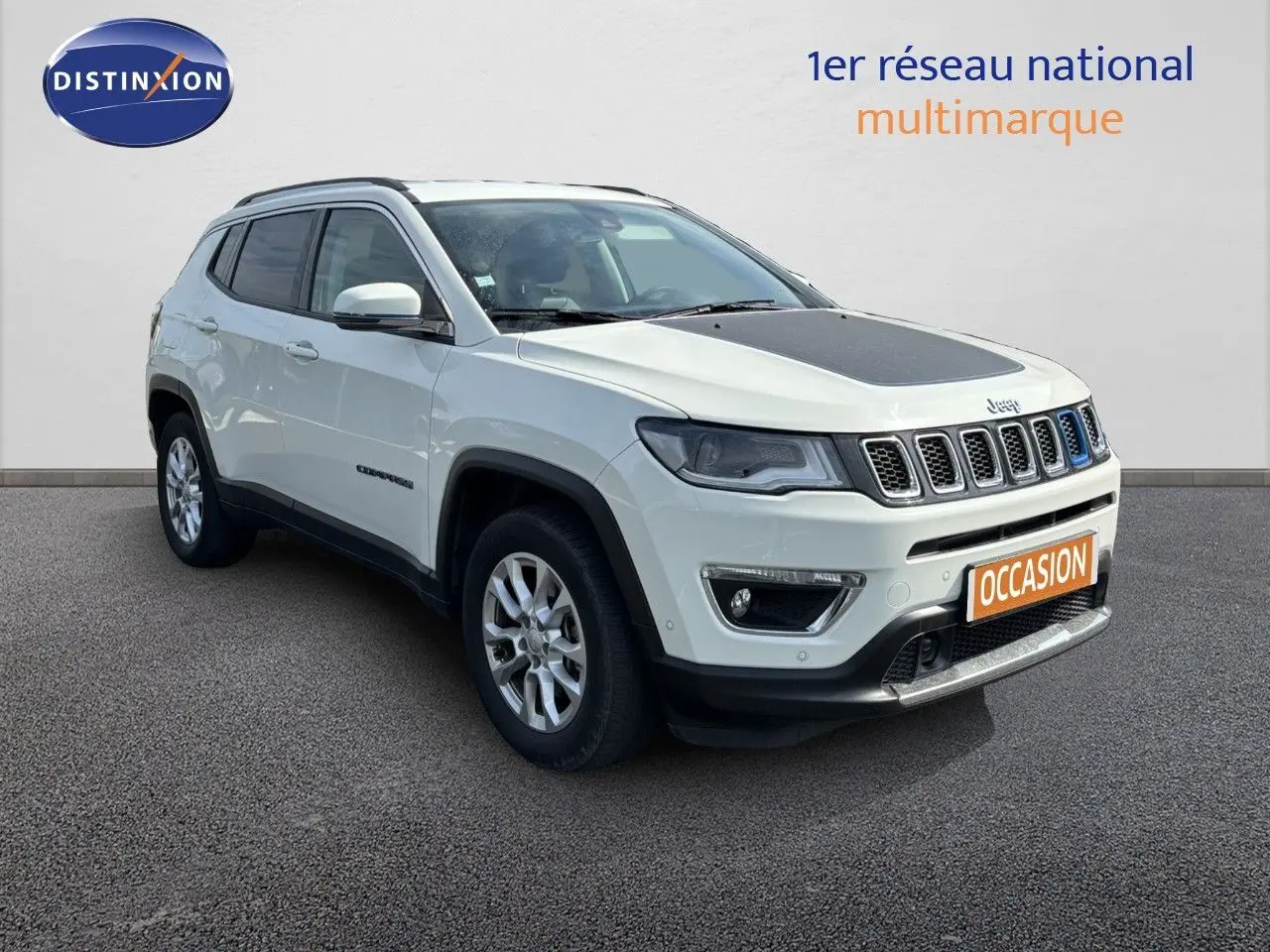 Jeep Compass blanc en 3/4 avant droit avec capot noir et calandre à sept fentes distinctives.