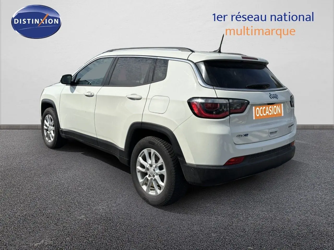 Jeep Compass blanc en 3/4 arrière côté gauche, SUV hybride rechargeable avec jantes alliage et toit noir.