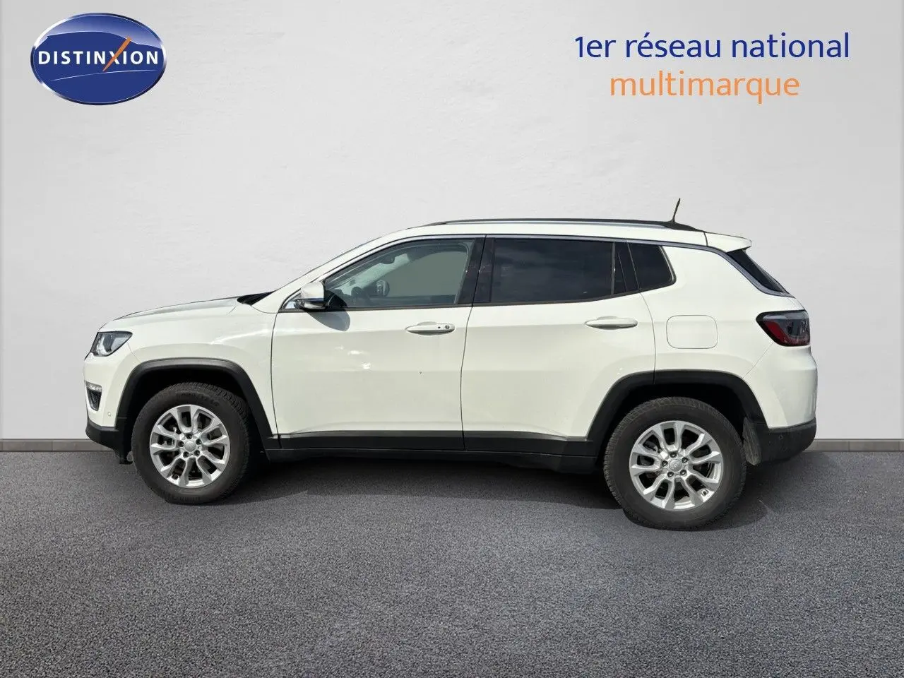 Profil côté gauche d'un Jeep Compass blanc 2021 hybride rechargeable avec jantes alliage et toit noir.