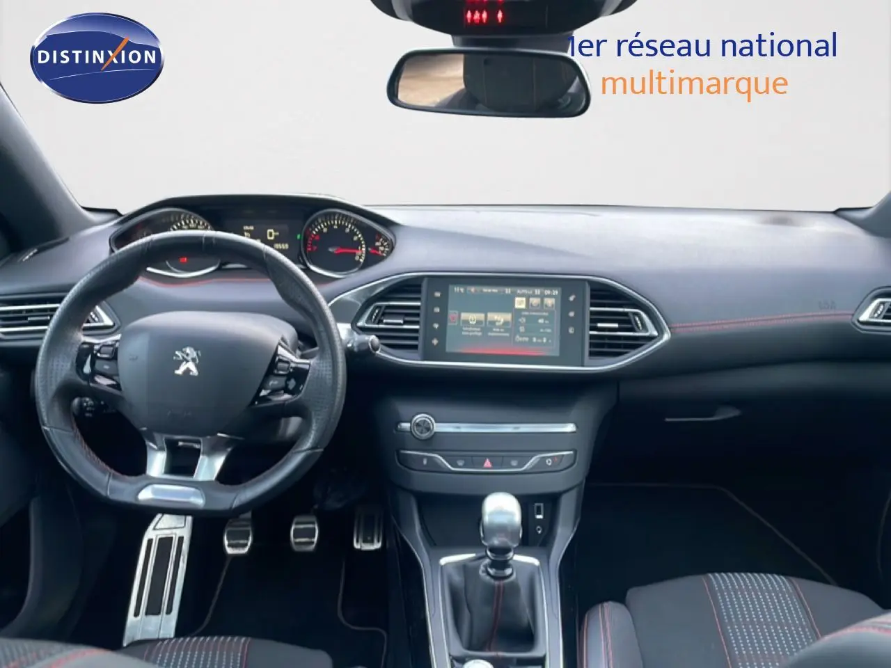 Vue intérieure avant de la Peugeot 308 GT Line 2017, tableau de bord noir avec volant sport et levier de vitesse manuel.