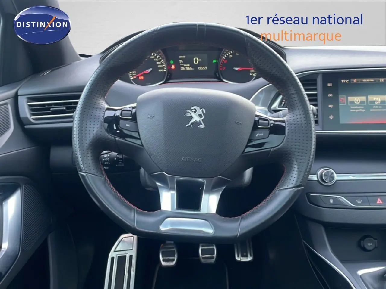 Vue intérieure centrée sur le volant en cuir perforé noir du Peugeot 308 GT Line 2017 avec tableau de bord et écran tactile.