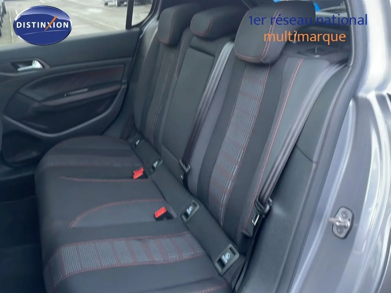 Vue intérieure côté droit sur les sièges arrière en tissu noir avec surpiqûres rouges d’une Peugeot 308 gris Artense.