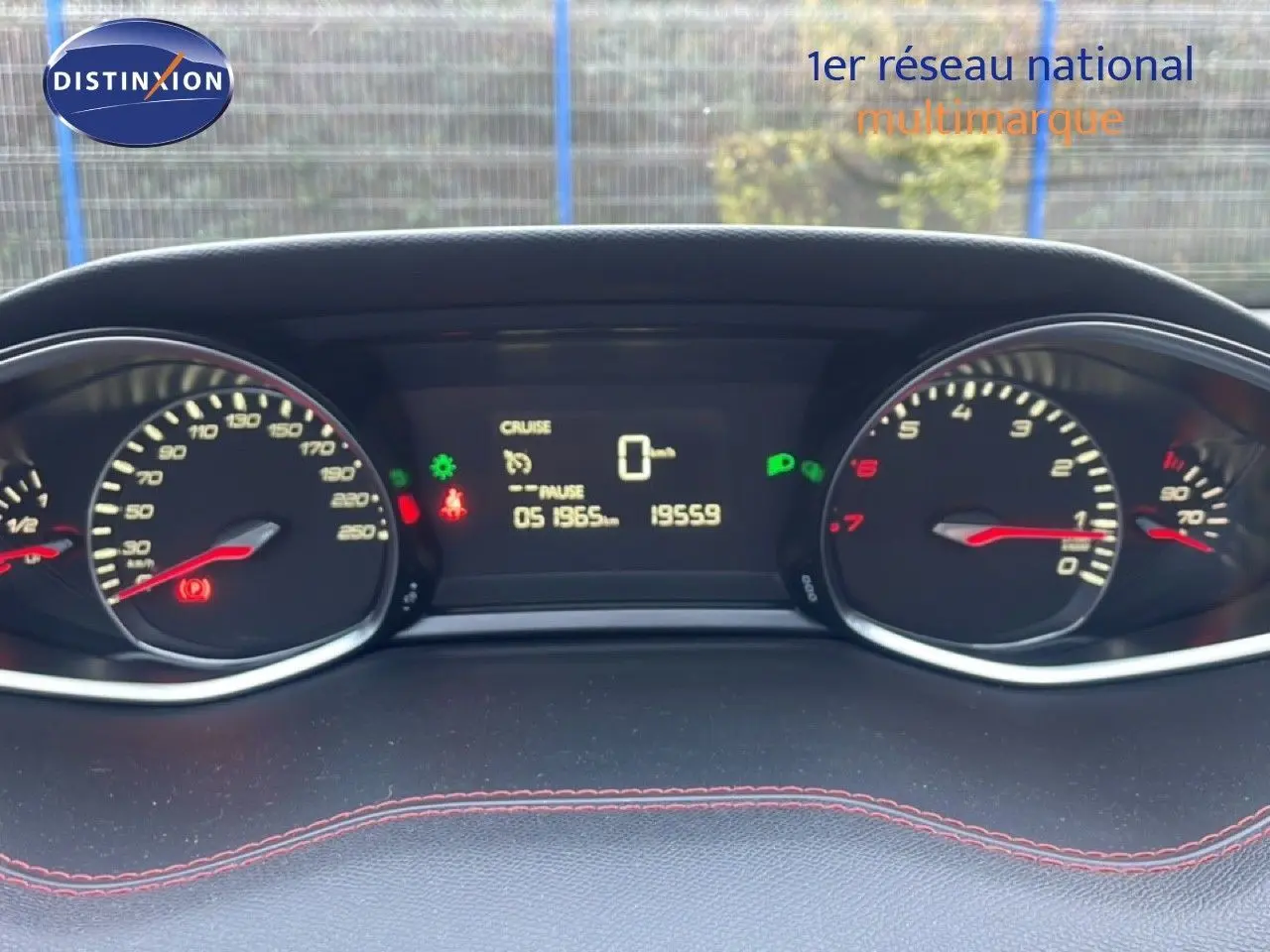 Vue rapprochée du tableau de bord de la Peugeot 308 gris Artense, affichant le compteur et l’ordinateur de bord allumés.