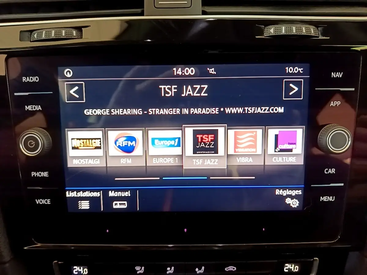 Écran tactile central affichant la radio TSF Jazz dans l'habitacle d'une Volkswagen Golf gris clair, vue de face.