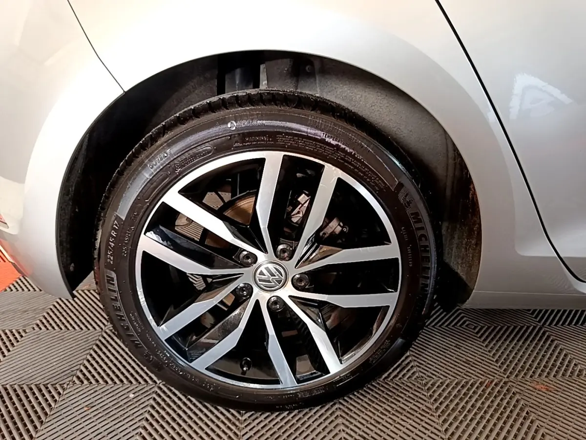 Gros plan sur la roue avant droite gris clair de la Volkswagen Golf 1.6 TDI avec jante alliage bicolore et logo VW central.