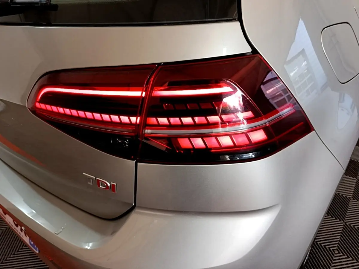 Gros plan sur le feu arrière droit rouge allumé d'une Volkswagen Golf gris clair diesel 2017.