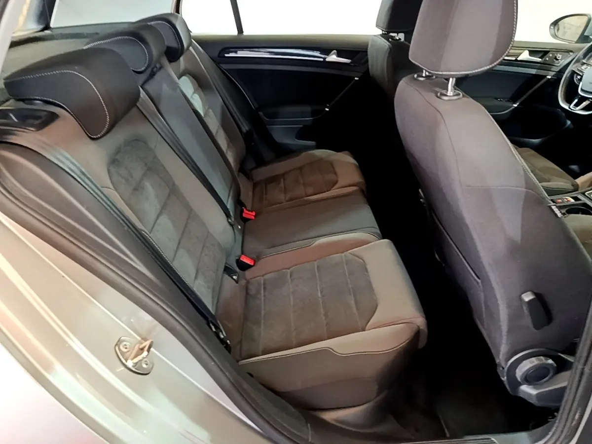 Vue intérieure côté gauche montrant la banquette arrière en tissu gris et partie avant du tableau de bord d'une Volkswagen Golf 2017.