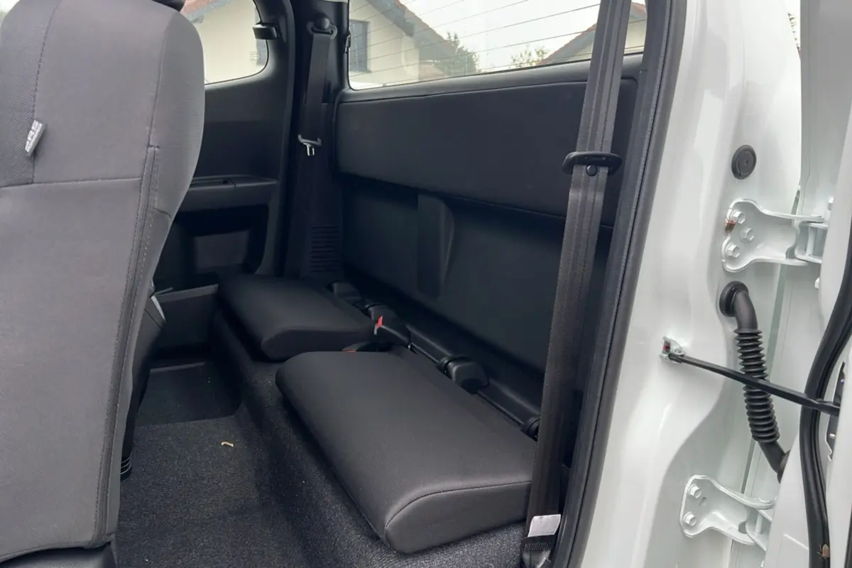 Vue intérieure arrière côté droit du pick-up Isuzu D-MAX Splash White, montrant les strapontins et la porte ouverte.