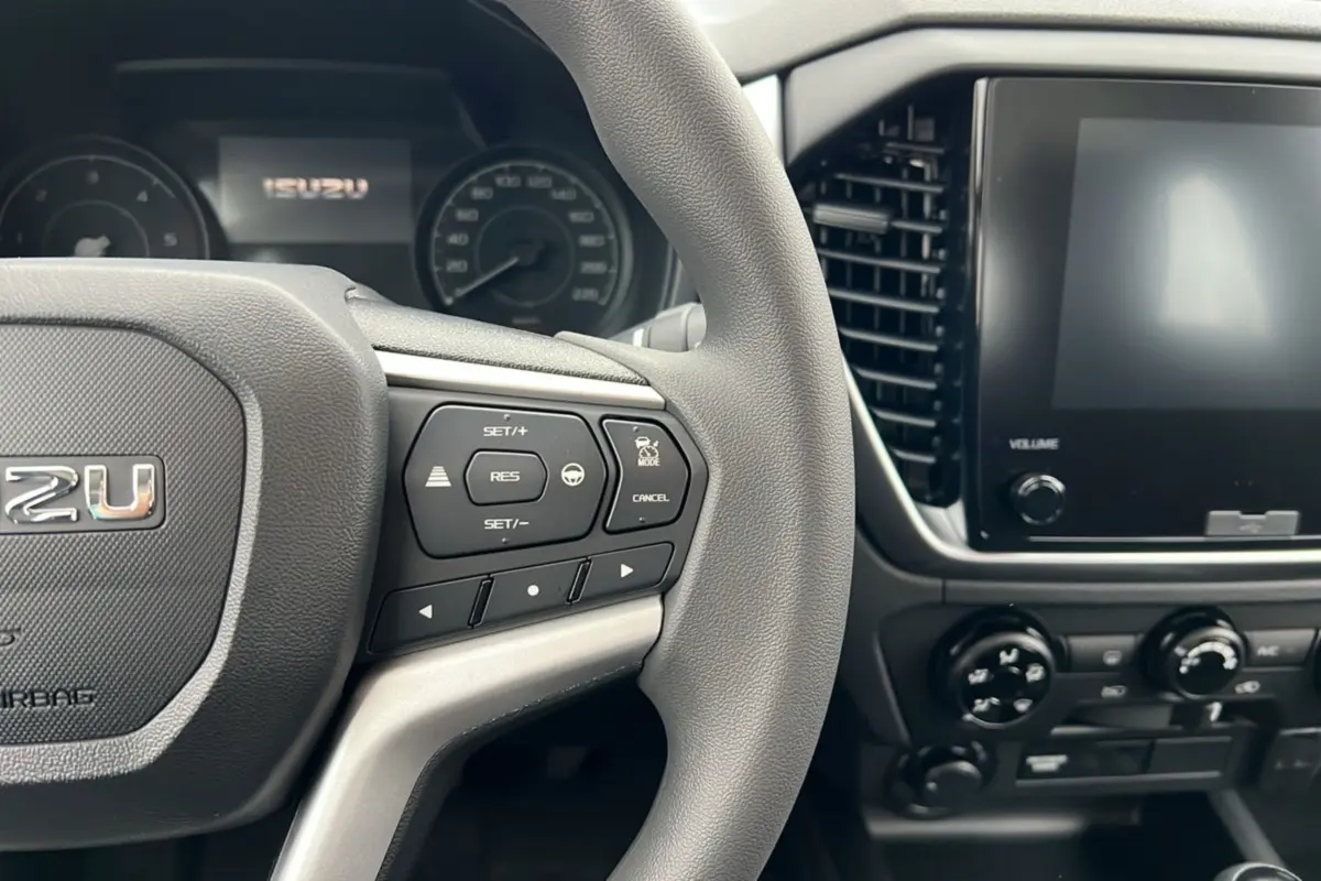 Vue rapprochée du volant multifonctions gris et de l’écran tactile du tableau de bord de l’Isuzu D-MAX 2026.