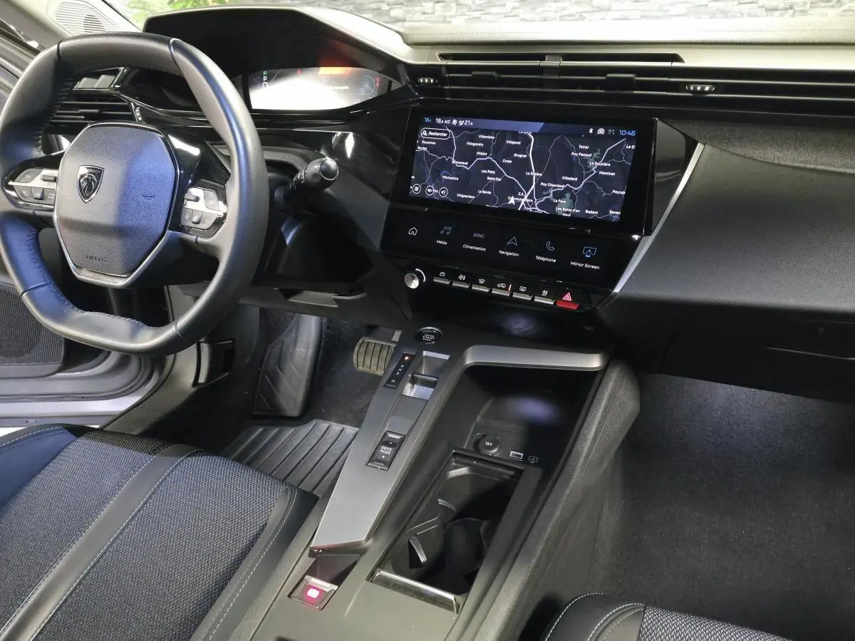Intérieur Peugeot 408 2025 vu côté conducteur, volant cuir, écran tactile 10'' avec navigation et console centrale moderne.