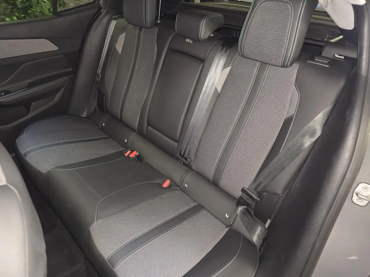 Vue latérale droite de la banquette arrière bi-matière gris et noir de la Peugeot 408 1.2i Hybrid Allure 2025.