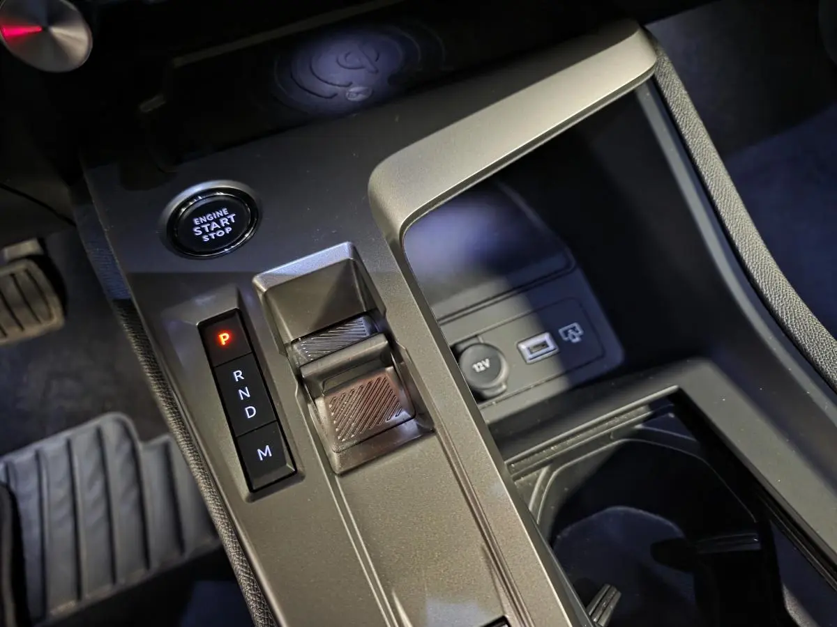 Gros plan sur la console centrale de la Peugeot 408 gris, montrant la commande de boîte auto et bouton start/stop.
