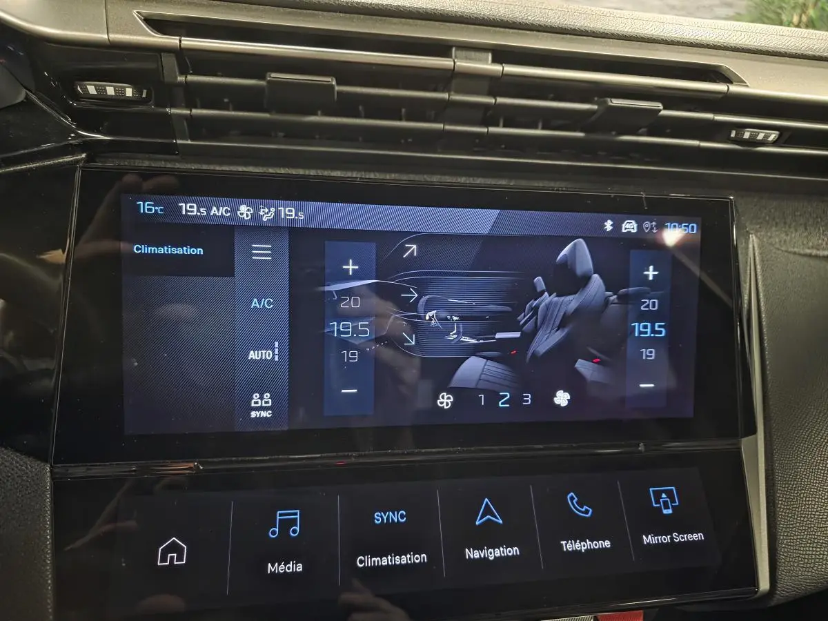 Écran tactile central du tableau de bord du Peugeot 408 gris, affichant les réglages de climatisation et navigation.