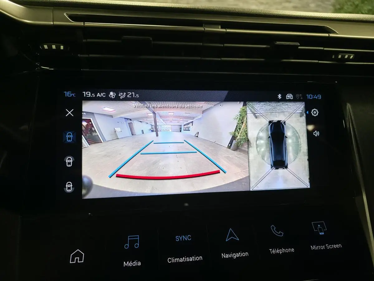 Écran tactile central de la Peugeot 408 gris montrant la caméra de recul et la vue 360° intérieure.