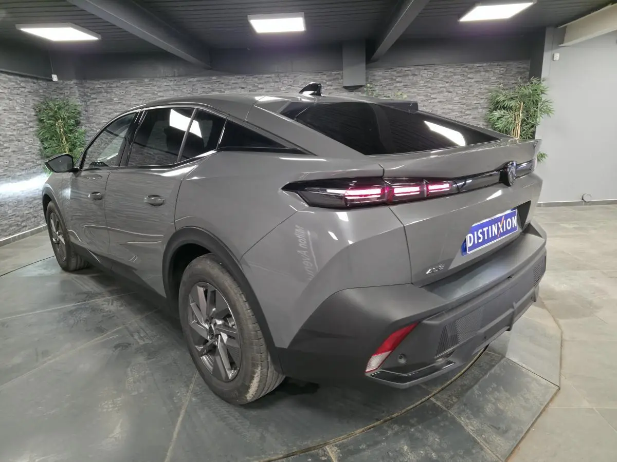 Vue 3/4 arrière droite d'une Peugeot 408 gris métallisé avec feux arrière LED et jantes alliage 17 pouces.