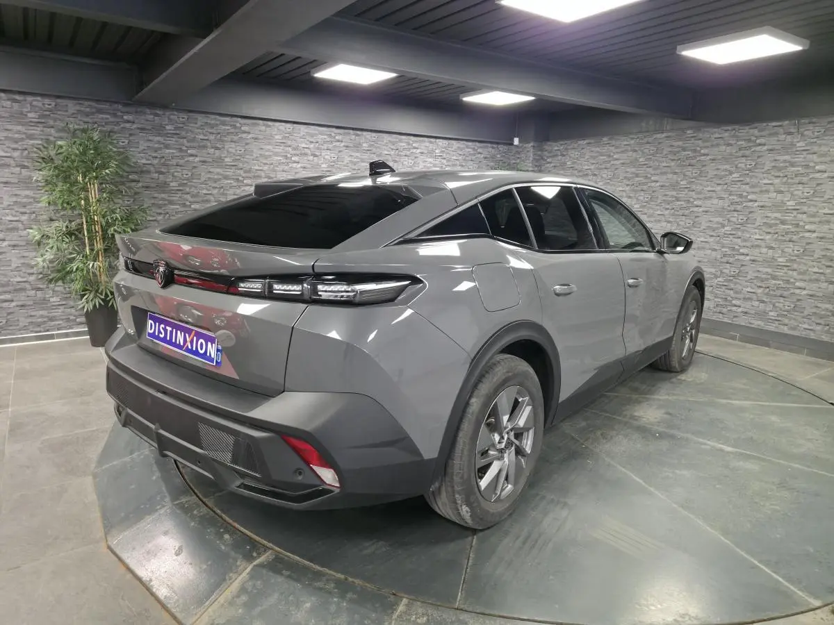 Vue 3/4 arrière droite d'une Peugeot 408 gris métallisé avec feux arrière LED et jantes alliage 17 pouces.