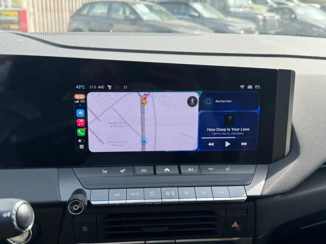 Vue rapprochée du tableau de bord de l'Opel Astra 2024, écran tactile affichant navigation et musique.