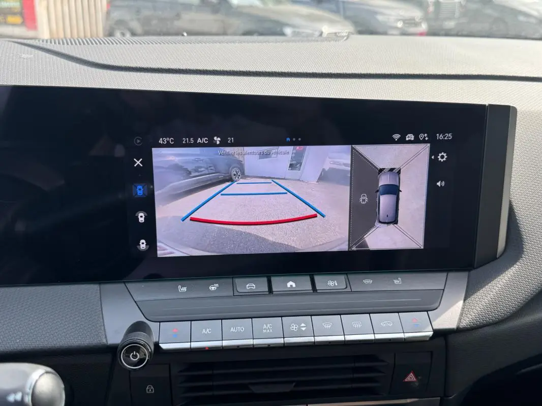 Vue intérieure de l'écran multimédia de l'Opel Astra gris 2024 montrant la caméra de recul et l'affichage 360° du véhicule.