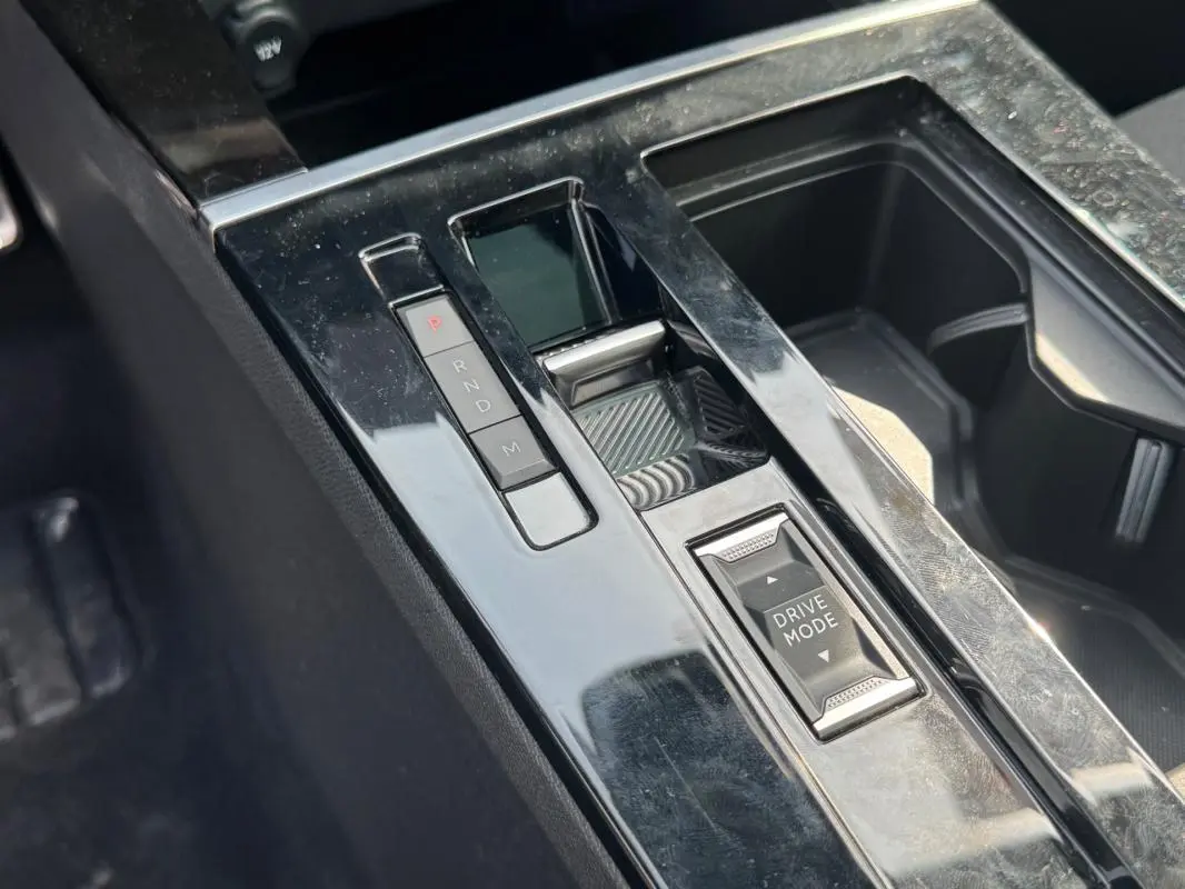 Gros plan sur la console centrale noire brillante de l’Opel Astra 2024 avec sélecteur de mode de conduite et boutons de boîte auto.