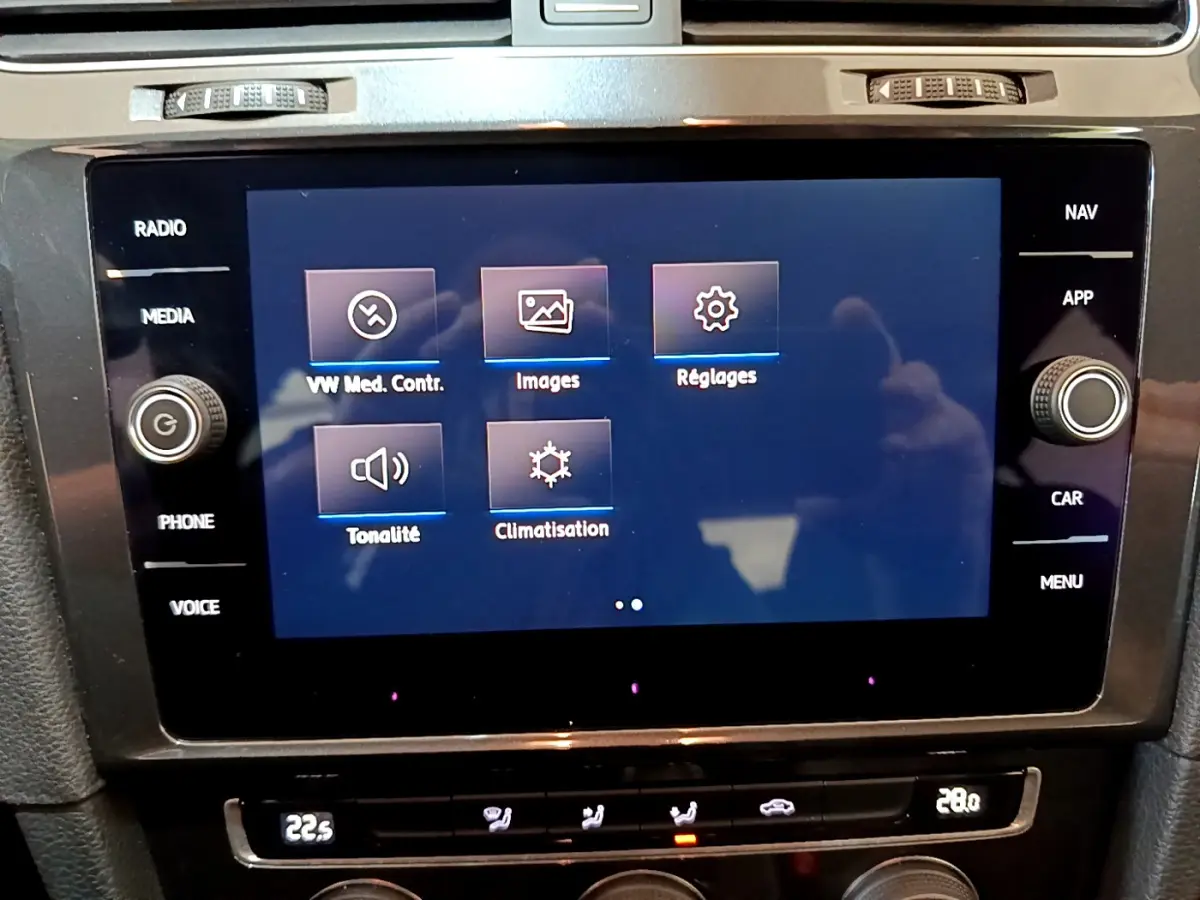 Écran tactile central de la Volkswagen Golf 2018 affichant les options multimédia et climatisation, intérieur noir.