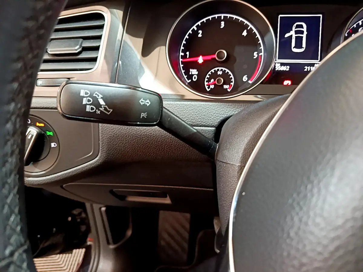 Gros plan sur le commodo gauche et le tableau de bord noir d'une Volkswagen Golf 2018, affichage digital et compte-tours visibles.