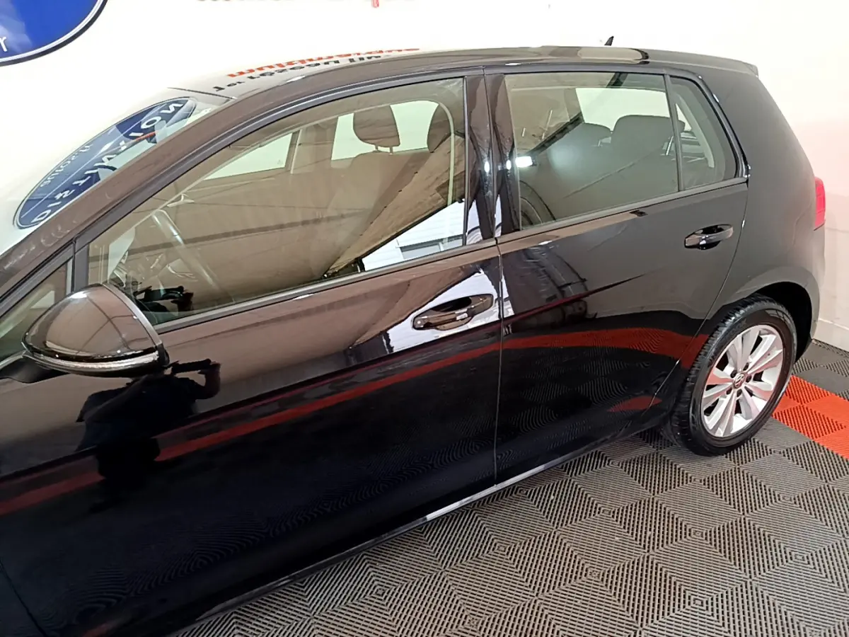 Profil côté gauche d'une Volkswagen Golf noire 2018 avec jantes alliage et rétroviseurs noirs brillants.