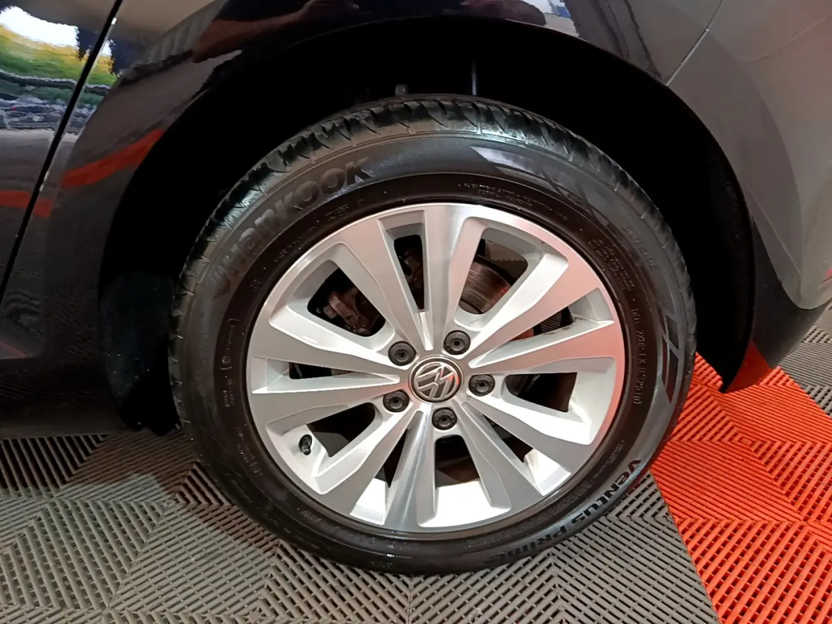 Gros plan sur la roue avant gauche avec jante argentée et pneu Hankook d'une Volkswagen Golf noire.
