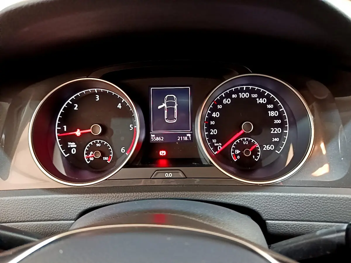 Tableau de bord de Volkswagen Golf noir 2018 avec compte-tours, compteur de vitesse et écran central affichant une porte ouverte.