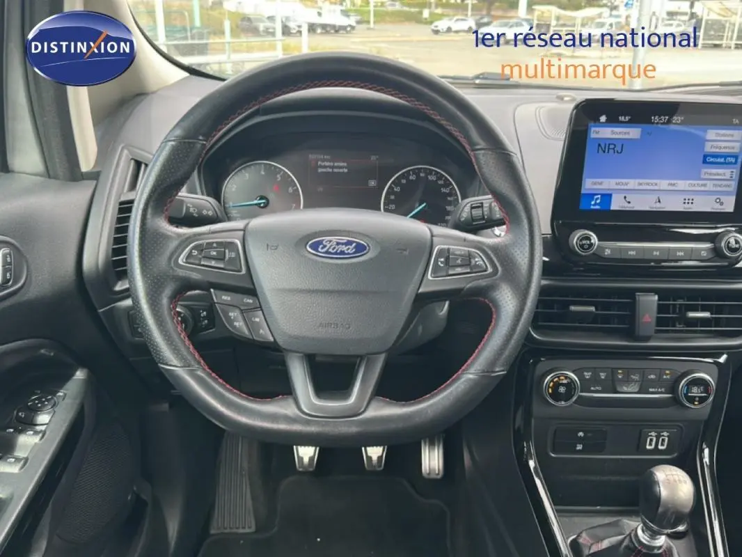 Vue intérieure centrée sur le volant Ford avec commandes intégrées et écran tactile du tableau de bord.