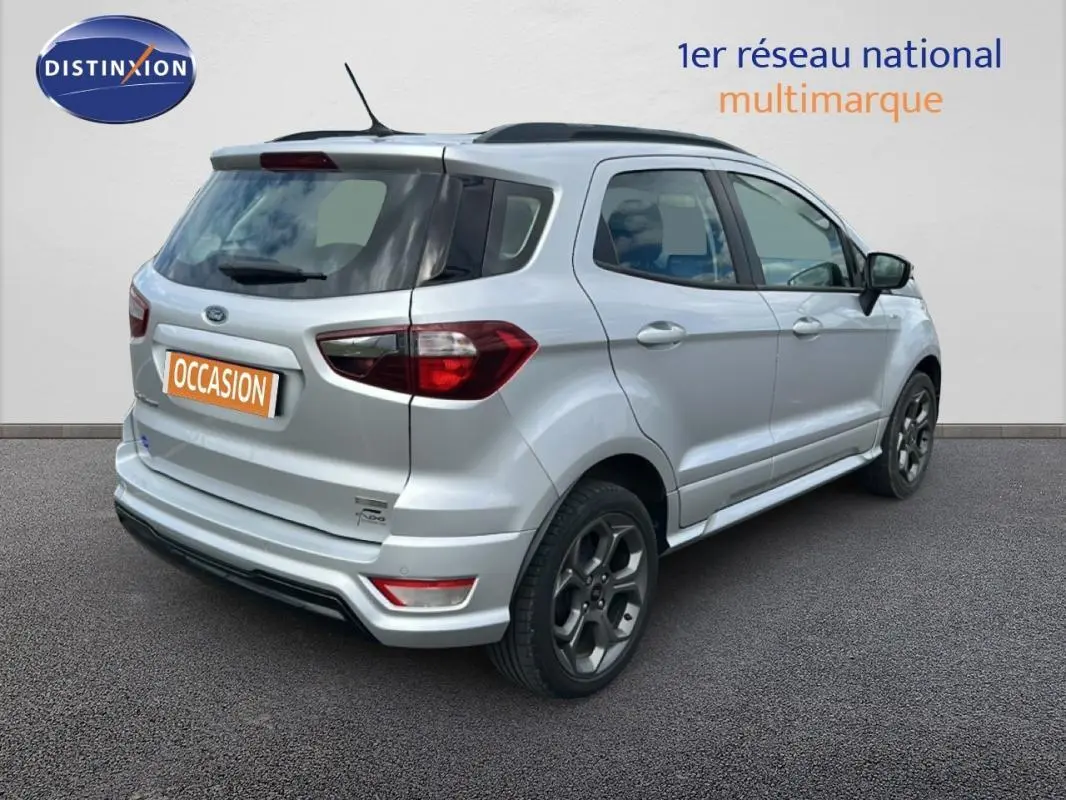 Vue 3/4 arrière droite d'un Ford EcoSport gris clair avec jantes alliage 17 pouces et barres de toit noires.