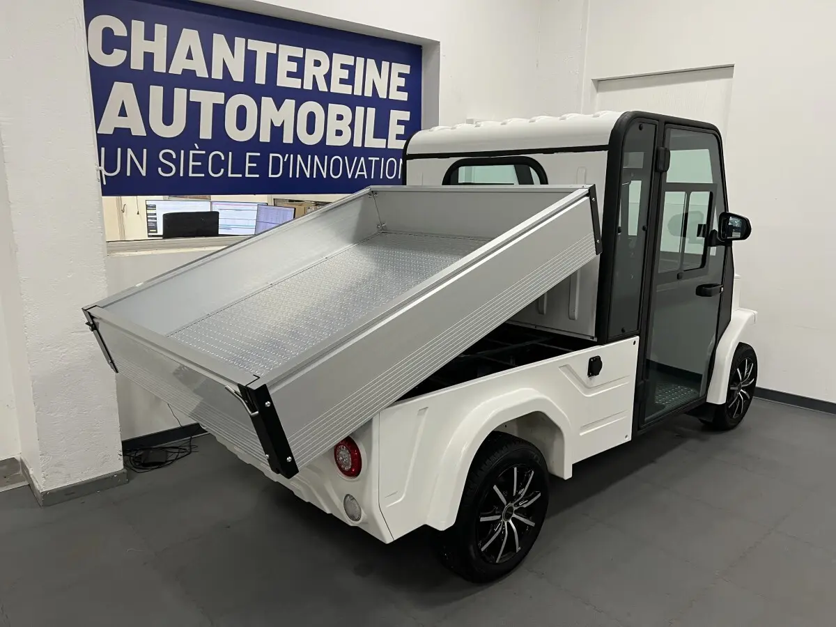 Vue 3/4 arrière droite du Liberty L7E H2 160 blanc avec kit ridelles relevé et jantes alliage 13 pouces noires.