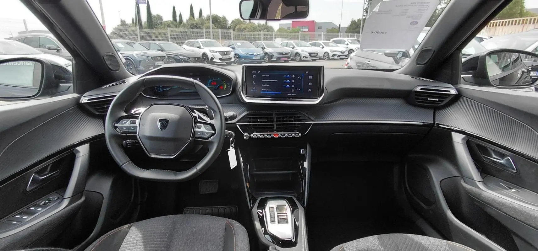 Intérieur noir du Peugeot 2008 Hybrid 145 e-DCS6 Style 2025, vue frontale sur le tableau de bord et volant compact.