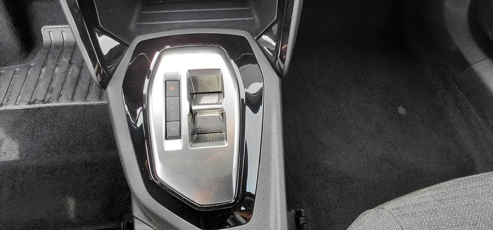 Gros plan sur la console centrale du Peugeot 2008 Hybrid 145 e-DCS6 Style 2025, avec levier de vitesses automatique noir et argent.
