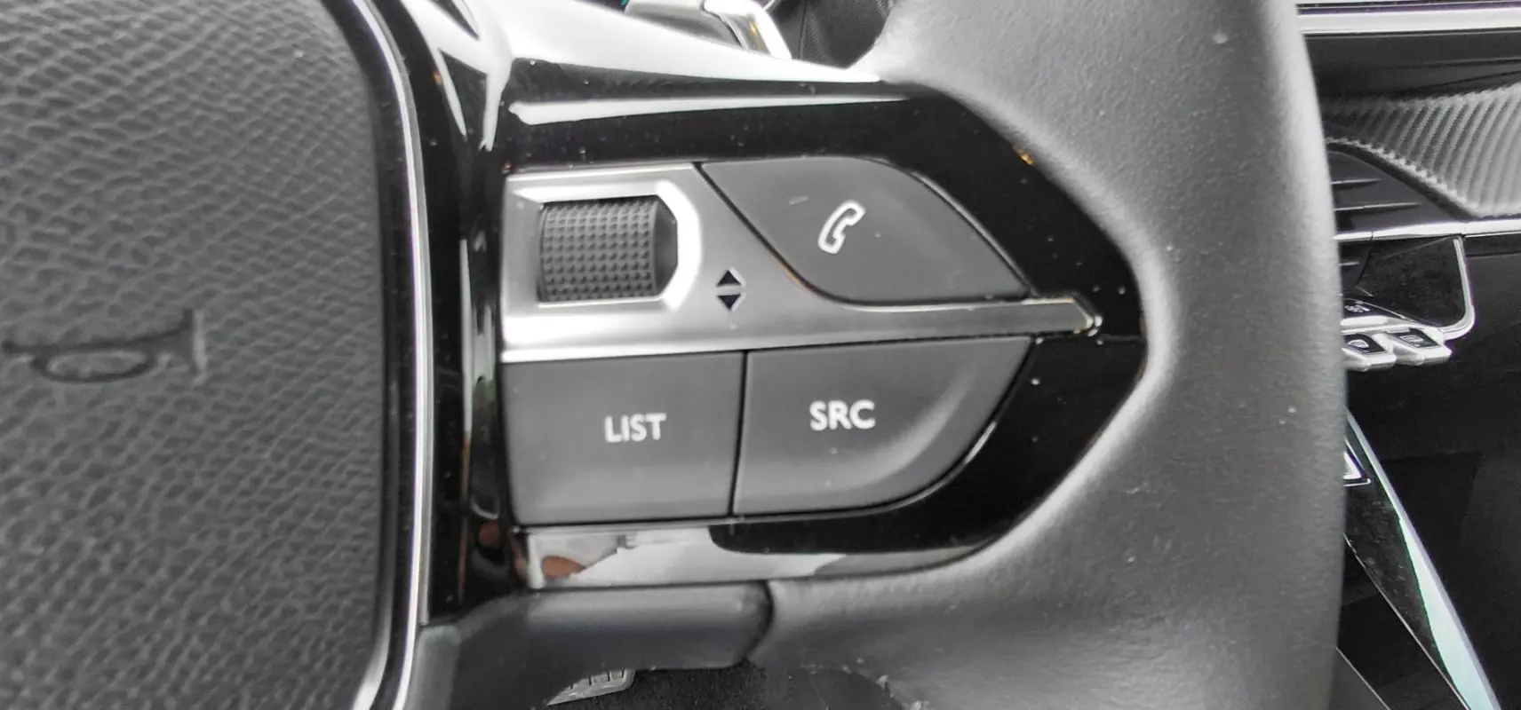 Détail du côté gauche du volant noir du Peugeot 2008 Hybrid 145 e-DCS6 Style 2025 avec commandes audio intégrées.