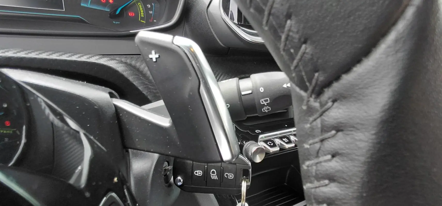 Gros plan sur la palette de changement de vitesse + au volant cuir noir du Peugeot 2008 Hybrid 145 e-DCS6 Style 2025.